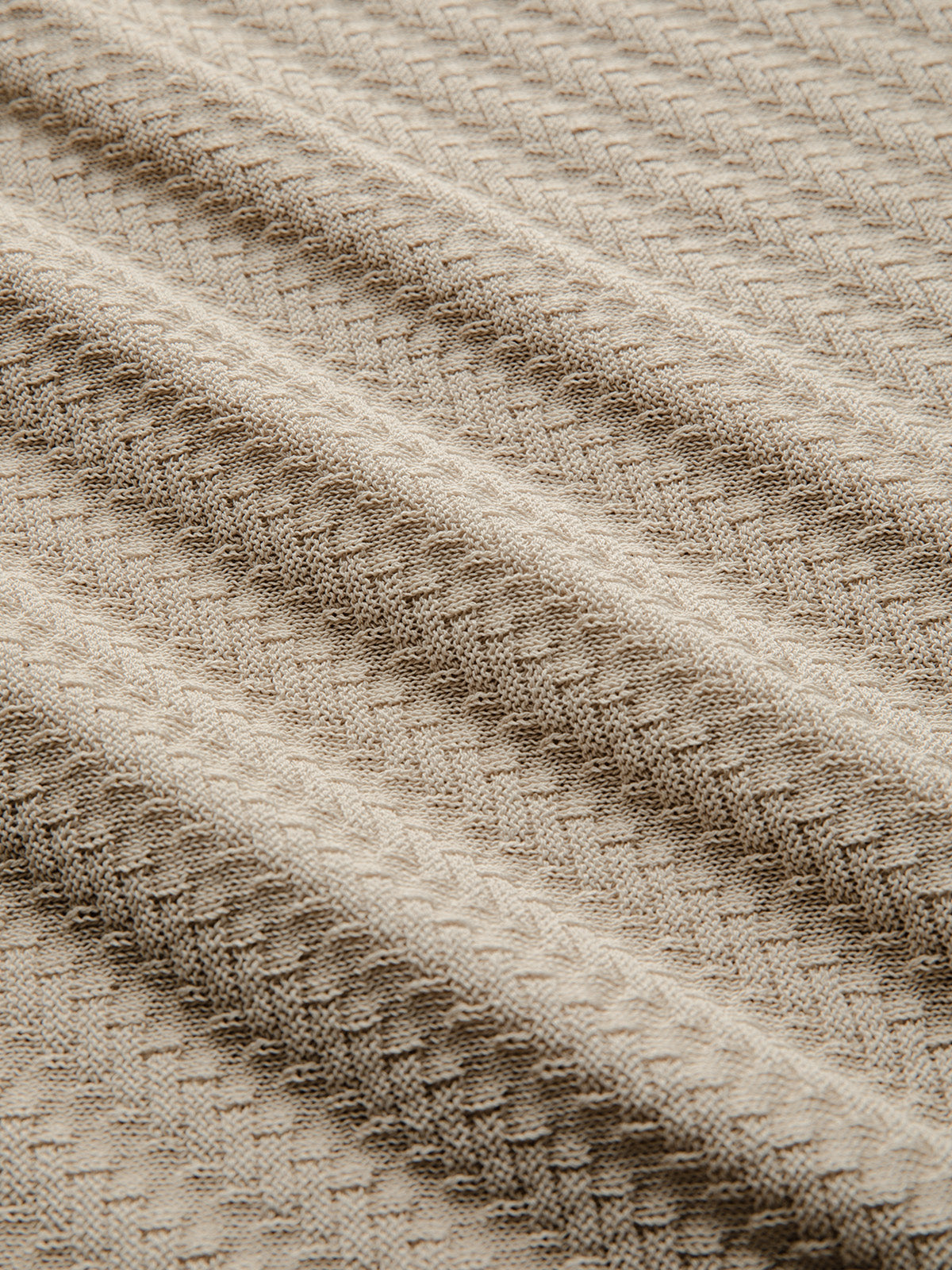 Close-up of off-white textured knit fabric