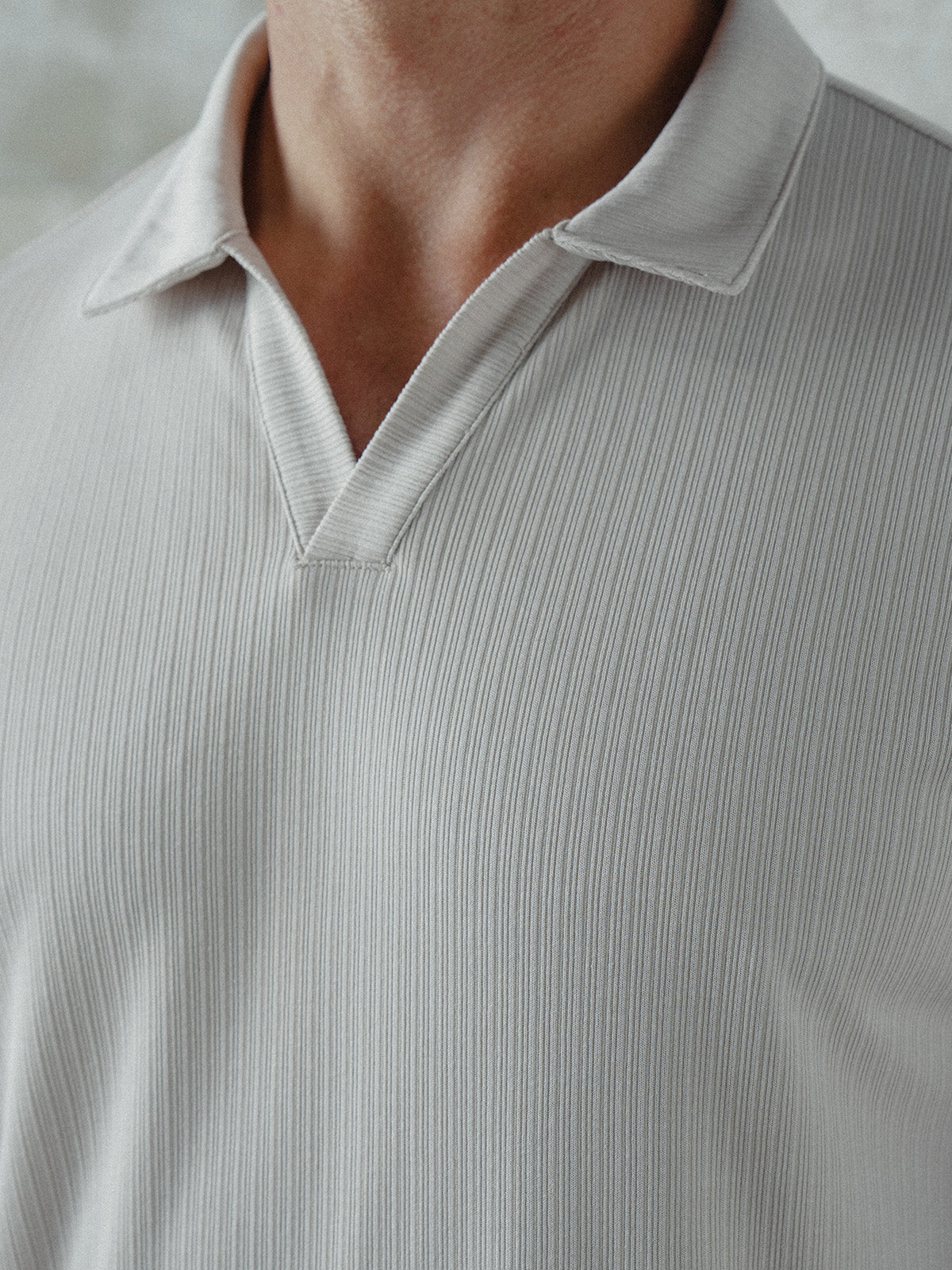 Man wearing a light gray ribbed polo